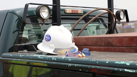Hard hat resting on a truck bed in the field